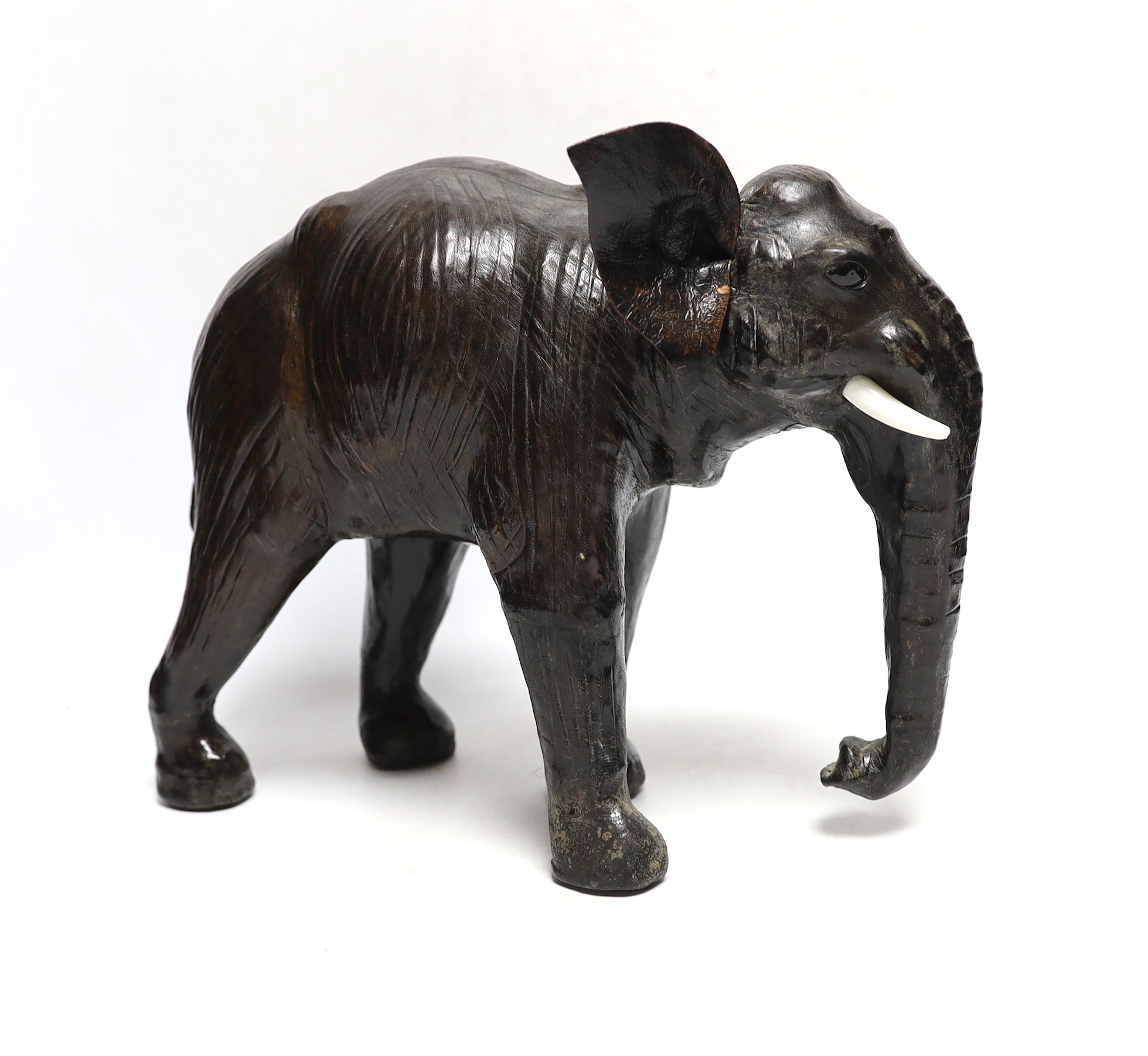 A leather elephant, stamped Liberty to the underside, 30cm wide